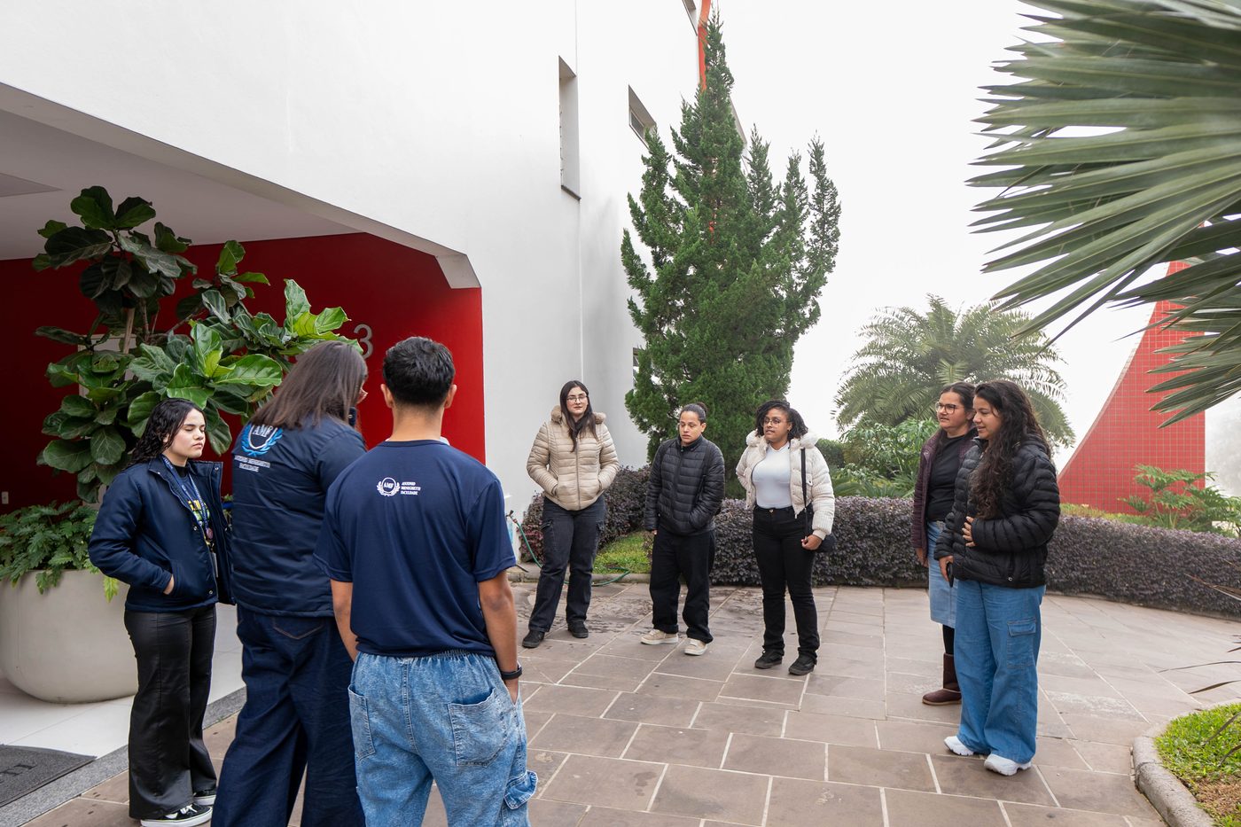 Grupo reunido na área externa da faculdade no início do tour